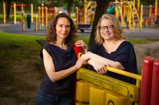 Two women, smiling, playground