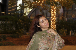 Girl with long brown hair, smiling, green scarf 